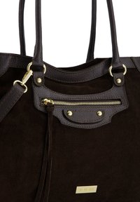 Ciemnobrązowa zamszowa torebka z elementami ze skóry, wyposażona w kieszeń na zamek, złote okucia i dwa solidne uchwyty. Widoczne logo.