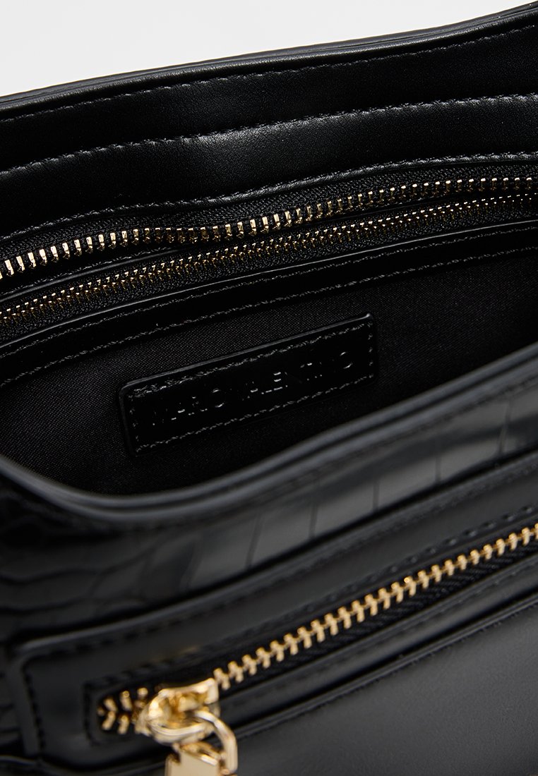 Schwarze Ledertasche mit goldenen Reißverschlüssen, die das offene Hauptfach und das Innere mit Reißverschlusstasche zeigt.