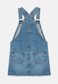 Denim overallkjole i lysebl�å med justerbare stropper, frontlommer og en rett kant. Inkluderer kontrasterende sømmer og rå kanter.
