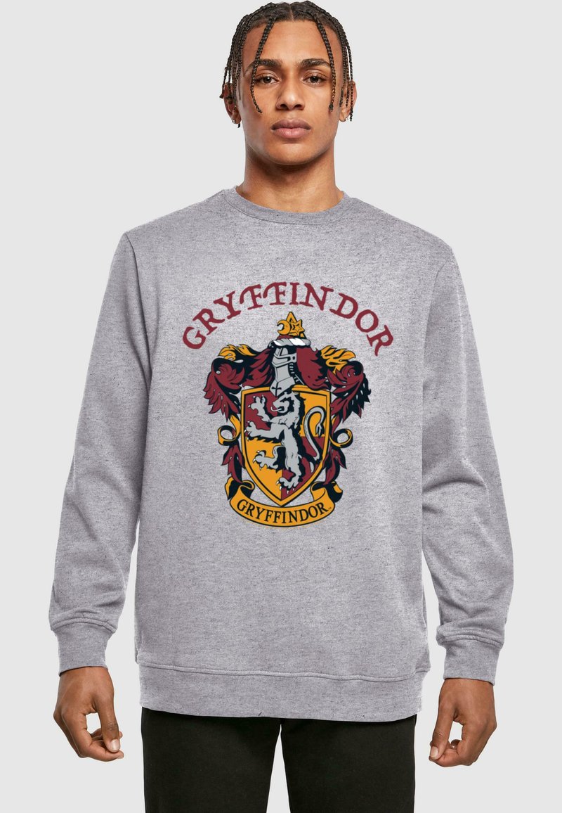 Szary sweter z kolorowym herbem Gryffindoru, z lwem, czerwonymi i złotymi akcentami oraz słowem "GRYFFINDOR" nad emblematem.