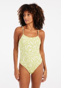 Eénstuk zwempak in lichtgroen met een abstract wit patroon, voorzien van dunne schouderbanden, hoge beenopeningen en een gladde textuur.