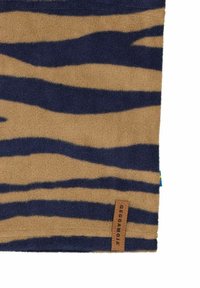Fleece peitto vaaleanruskeana, jossa on tummansinisiä tiikeri-raitoja. Mukana ruskea nahkainen etiketti, jossa on kohokuvioitu teksti. Pehmeä rakenne ja suorakulmainen muoto.