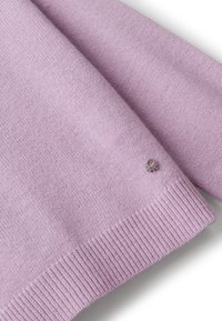 Manica di un morbido maglione a maglia color lavanda con polsino a coste e un piccolo logo del marchio in argento vicino all'orlo su sfondo bianco.