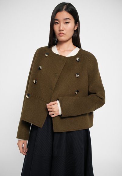 Olive roheline villane segajakk lühikese disainiga, topeltkinnise ja suurte mustade nööpidega. Tekstureeritud kangas, laiad varrukad.