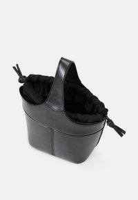 Μαύρη δερμάτινη τσάντα τύπου bucket με μαλακή μαύρη υφασμάτινη επένδυση, δομημένο σχέδιο και επάνω χερούλι με κόμπο.