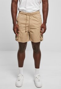 Shorts cargo en khaki avec une taille élastique, cordon de serrage et poches latérales. Fabriqués en tissu léger, avec une coupe décontractée.