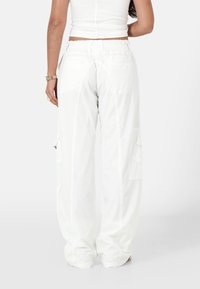 Witte cargobroek met een elastische tailleband, voorzien van zijzakken en een relaxte pasvorm. Lichtgewicht stof met een gladde textuur.