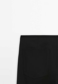 Pantalon noir avec une poche arrière rectangulaire. Le tissu semble lisse avec un léger éclat. La ceinture est plate et les coutures sont minimales.