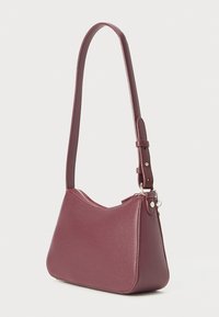 Sac à main en cuir bordeaux avec une forme structurée, une seule bandoulière et une fermeture éclair. Surface extérieure texturée pour un détail supplémentaire.