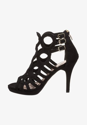 Schwarze High-Heel-Sandale mit runden Ausschnitten, drei Knöchelriemen mit silbernen Schnallen und einem Reißverschluss auf der Rückseite.
