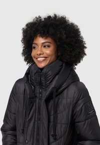 Black puffer jacket with a high collar, textured quilted design, front zipper, two drawstring adjustments, and branded fabric patch.