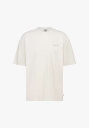 Camiseta de algodón color crema con un ajuste relajado, mangas cortas y escote redondo. Presenta la inscripción "Nature Club" en letras sutiles.