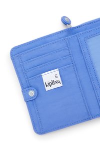 Sininen kangaslompakko, jossa on useita korttipaikkoja, napsautettavalla suljintekniikalla, läpinäkyvä ID-tasku ja valkoinen Kipling-label sisällä.