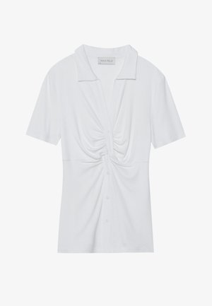 Blusa blanca de manga corta con collar, con un detalle de nudo retorcido en la parte delantera y una tapeta de botones. Textura ribeteada lisa.