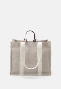 Borsa tote in tela di colore grigio chiaro con doppi manici bianchi. Presenta un logo in rilievo e una forma strutturata con apertura superiore.