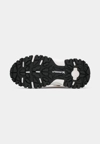 Suola di una scarpa da trekking bianca e nera con scanalature profonde, dotata del logo Michelin e del marchio "PRIMIGI" sulla suola.