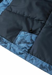 Ciemnoniebieska kurtka puchowa z tkaniny, z dolną kieszenią z niebieską wzorzystą klapką oraz czarnym regulatorem do ściągania.