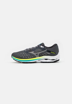 Zapatilla de correr gris oscuro con acentos en verde y amarillo, suela blanca y texto "Wave Rider 24" en la zona del talón, mostrada de lado.