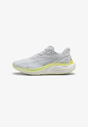 Chaussure de course gris clair et blanc avec des accents jaunes, design à lacets, semelle coussinée, et logo Puma sur le talon et le côté.