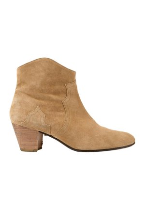 Bottine en suède beige avec un petit talon en bois empilé bas et une couture décorative sur le côté, vue de l'extérieur.