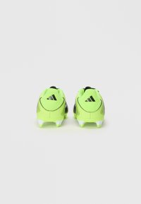Neon groene en zwarte voetbalschoenen met een gestructureerde bovenkant, twee zwarte strepen op de hiel en witte noppen voor grip.
