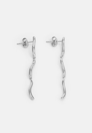 Silver metal earrings with wavy design, featuring two linked, elongated elements. Smooth texture and polished finish. Post-back closure.
