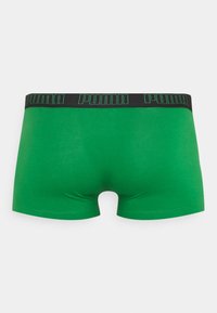 Grüne Boxershorts aus dehnbarem Material, mit einem schwarzen Bund, auf dem das "PUMA"-Logo in grüner Schrift aufgedruckt ist.