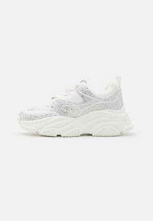 White sneakers featuring a textured upper adorned with silver rhinestones, thick sole, and padded collar for comfort and support.