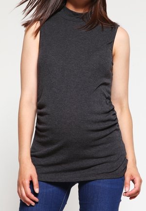 Ärmelloses dunkelgraues Top mit Stehkragen und gerafften Seiten, getragen von einer Person in blauen Jeans vor einem einfarbigen Hintergrund.