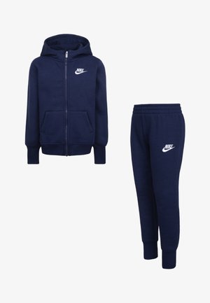 Tamno plavi dukserica s kapuljačom i trenirka izrađeni od mekanog materijala, sa punim patentnim zatvaračem, dva prednja džepa i bijelim Nike logotipom na oba komada.