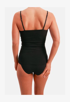 Camiseta negra sin mangas con tirantes finos ajustables, diseño ceñido, textura suave y dobladillo curvado, combinada con ropa interior negra sin costuras.