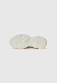 White sneaker sole with a textured, wavy design. Features ridges and grooves for grip. Material appears rubbery and flexible.