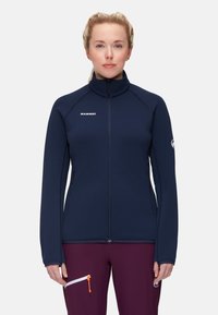 Giacca a zip blu navy con colletto alto, realizzata in tessuto morbido, con logo sul petto e tasche laterali con zip.