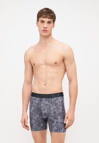 Szürke boxer alsónadrág fekete "UNDER" logós derékkal, sötétebb szürke árnyalatú geometrikus mintázattal, rugalmas anyagból készült.