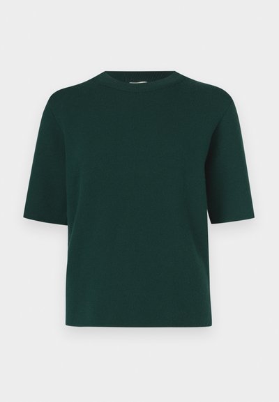 Zaļš īss piedurkņu krekls no mīksta auduma ar apaļu kakla izgriezumu un brīvu piegriezumu, bez redzamiem rakstiem vai rotājumiem.