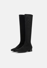 Pair of tall black suede boots with low block heels, standing side by side on a white background.