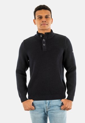 Pullover a coste blu navy con collo alto, pannello con tre bottoni e maniche lunghe. Presenta una vita aderente e un tessuto texturizzato.