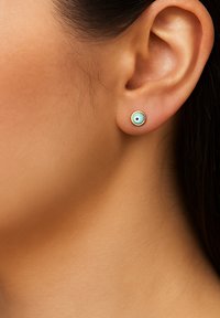 Ohrringe mit einem kreisförmigen Design, das ein hellblaues Zentrum und einen schwarzen Punkt aufweist, eingearbeitet in einen goldfarbenen Metallrahmen. Polierte Oberfläche.