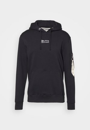 Schwarzer Hoodie aus weichem Baumwollstoff, mit einer Front-Kängurutasche, verstellbarem Kapuzenzug und einer seitlichen Reißverschlusstasche mit angehängtem Etikett.