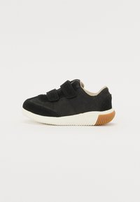 Scarpa in suede nero con due fasce in velcro, rivestimento beige e suola in gomma bianca con battistrada marrone texturizzato per una migliore aderenza.