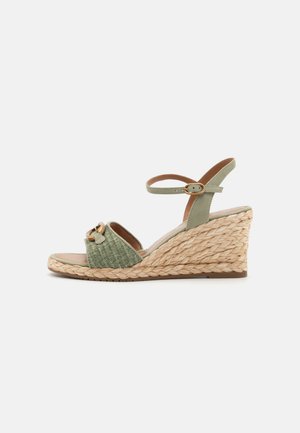 Zöld espadrille wedge szandál, szőtt juta talpakkal, nyitott orrával, bokapánttal és díszes masnival a felsőrészén.