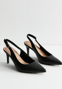 Décolleté neri con punta a punta, superficie texture e un sottile tacco a spillo. Cinturino con fibbia alla caviglia per la regolazione.