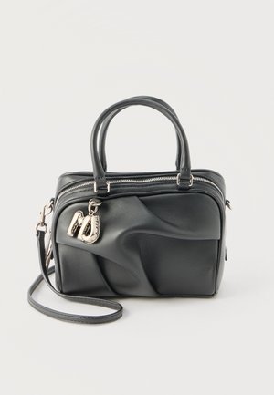 Black leather handbag with textured wave design, double handles, detachable shoulder strap, top zipper, and silver letter M charm.