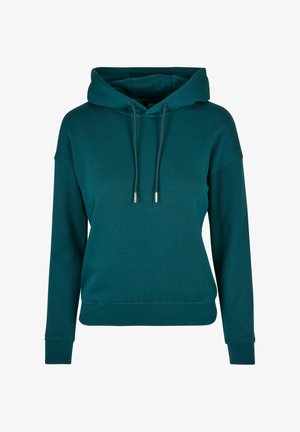 Mėlynas kapisonas pagamintas iš švelnaus medvilnės mišinio, su stumdomu gaubtu, šonkaulinėmis rankovėmis ir apačia, bei laisvu siluetu. Tinkamas tekstūros ir minimalizmo dizainas.