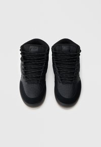 Crne tenisice s teksturiranim gornjim dijelom od tkanine, perforiranim detaljima i crnim vezicama. Imaju diskretan logo na jeziku i gumeni potplat.