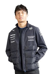 Granatowa kurtka puchowa z gładką górną częścią i teksturowanym, pikowanym dołem. Posiada stójkę oraz logo marki na rękawach i klatce piersiowej.