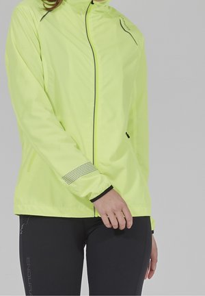 Fluorescerande gul jacka med hög krage, frontdragkedja och reflexdetaljer. Har nätmaterial på ärmarna och är tillverkad av vattentätt material.