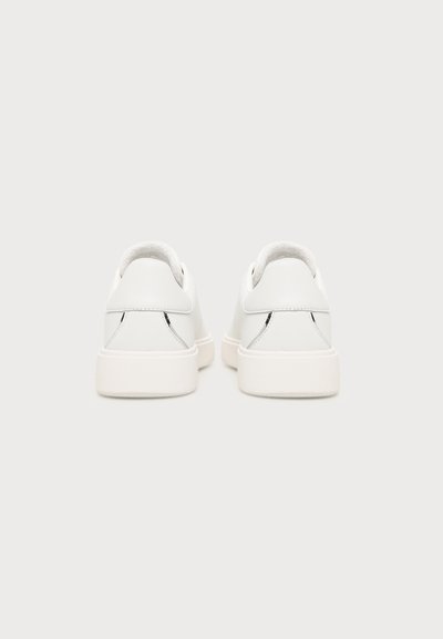 Pair of white low-top sneakers shown from the back with clean lines and minimal design on a light gray background.