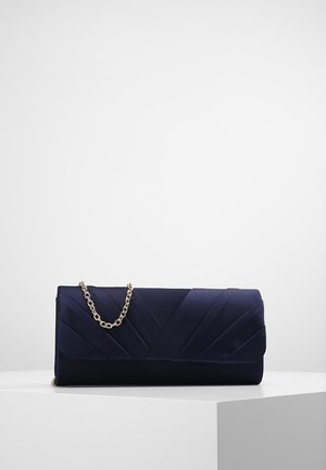 Laivastonsininen suorakaiteen muotoinen clutch-laukku, jossa on vinot poimut ja lyhyt kullanvärinen ketjulenksu, lepää valkoisella jalustalla.