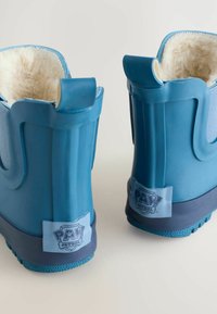 Stivali di gomma blu con morbida fodera in pelliccia, lati testurizzati e suola con grip a motivo. Presentano un logo "PAW Patrol" sul retro.